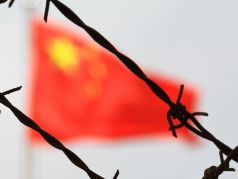 Флаг КНР и колючая проволока. Фото:quillette.com
