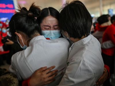 Медицинский работник из китайской провинции Цзилинь, в центре, плачет, обнимая медсестер из города Ухань 8 апреля. Фото: Hector Retamal / AFP / Getty Images