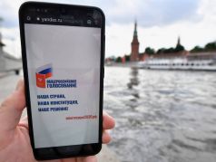 Агитационный плакат ко дню голосования по Конституции на экране смартфона. Фото: Александр Миридонов / Коммерсант