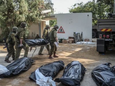 Солдаты ЦАХАЛ собирают тела в кибуце Кфар-Аза. Фото: Ilia Yefimovich /dpa